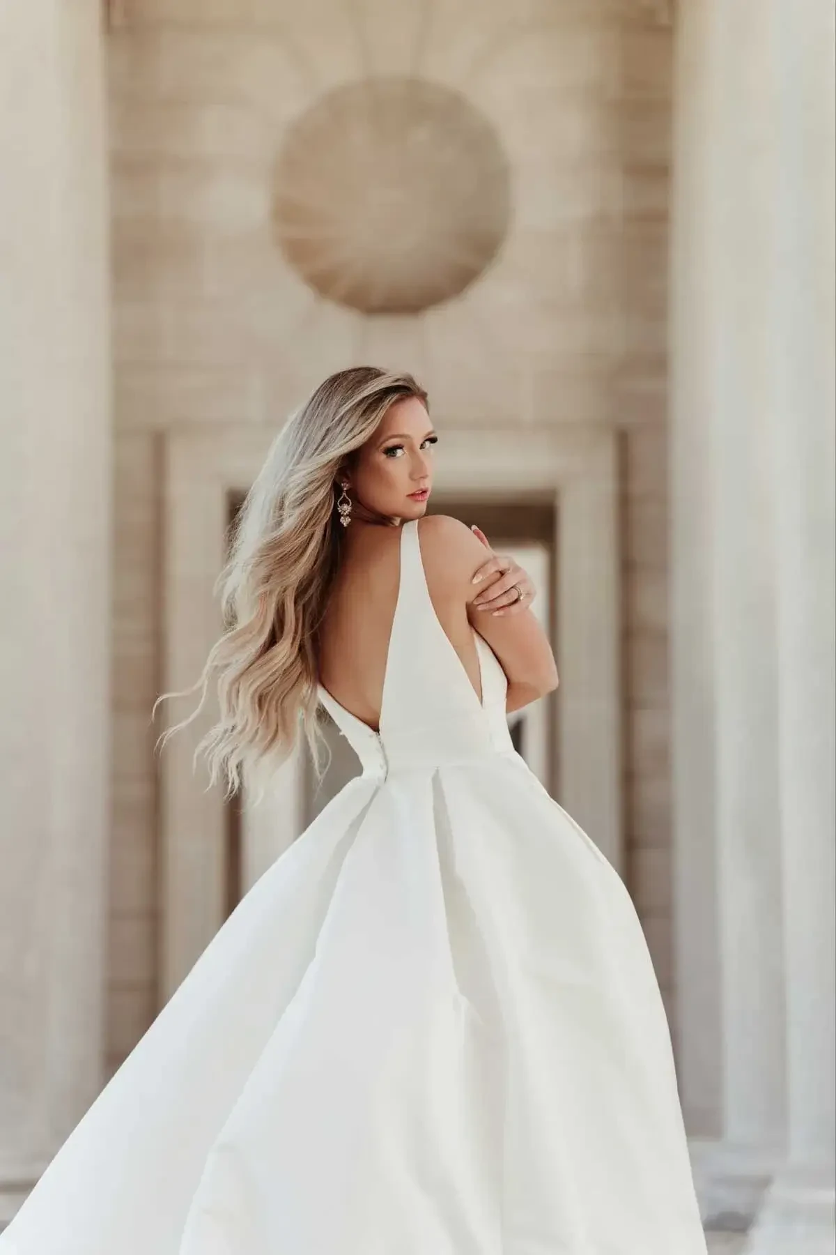 model is wearing a sleeveless a-line bridal gown with a v-neckline