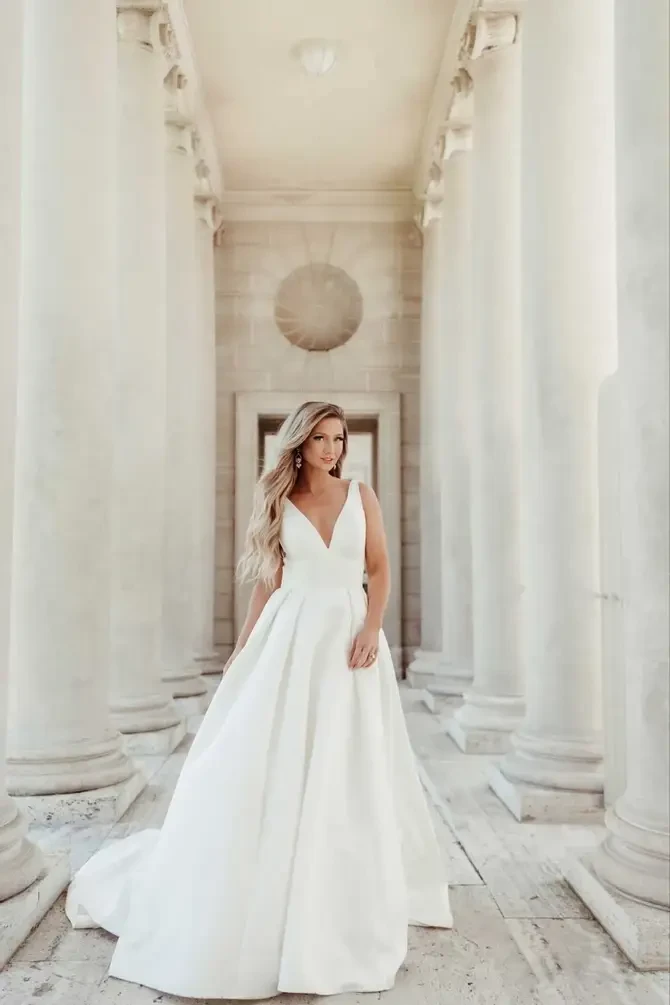 model is wearing a sleeveless a-line bridal gown with a v-neckline