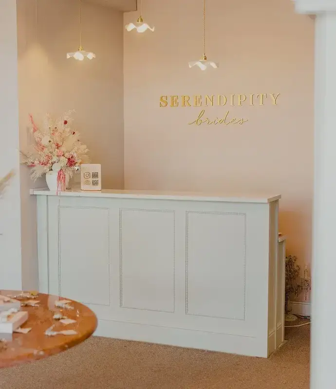 A light-colored reception desk with a sign that says 