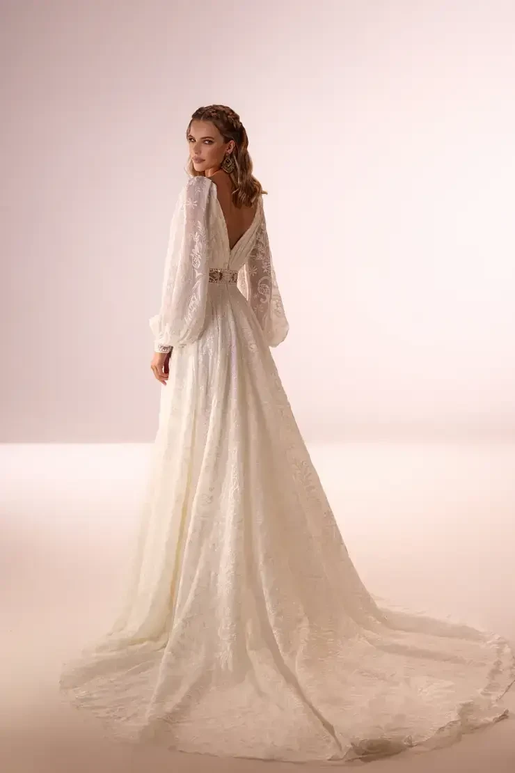 model is wearing a long sleeve boho bridal gown