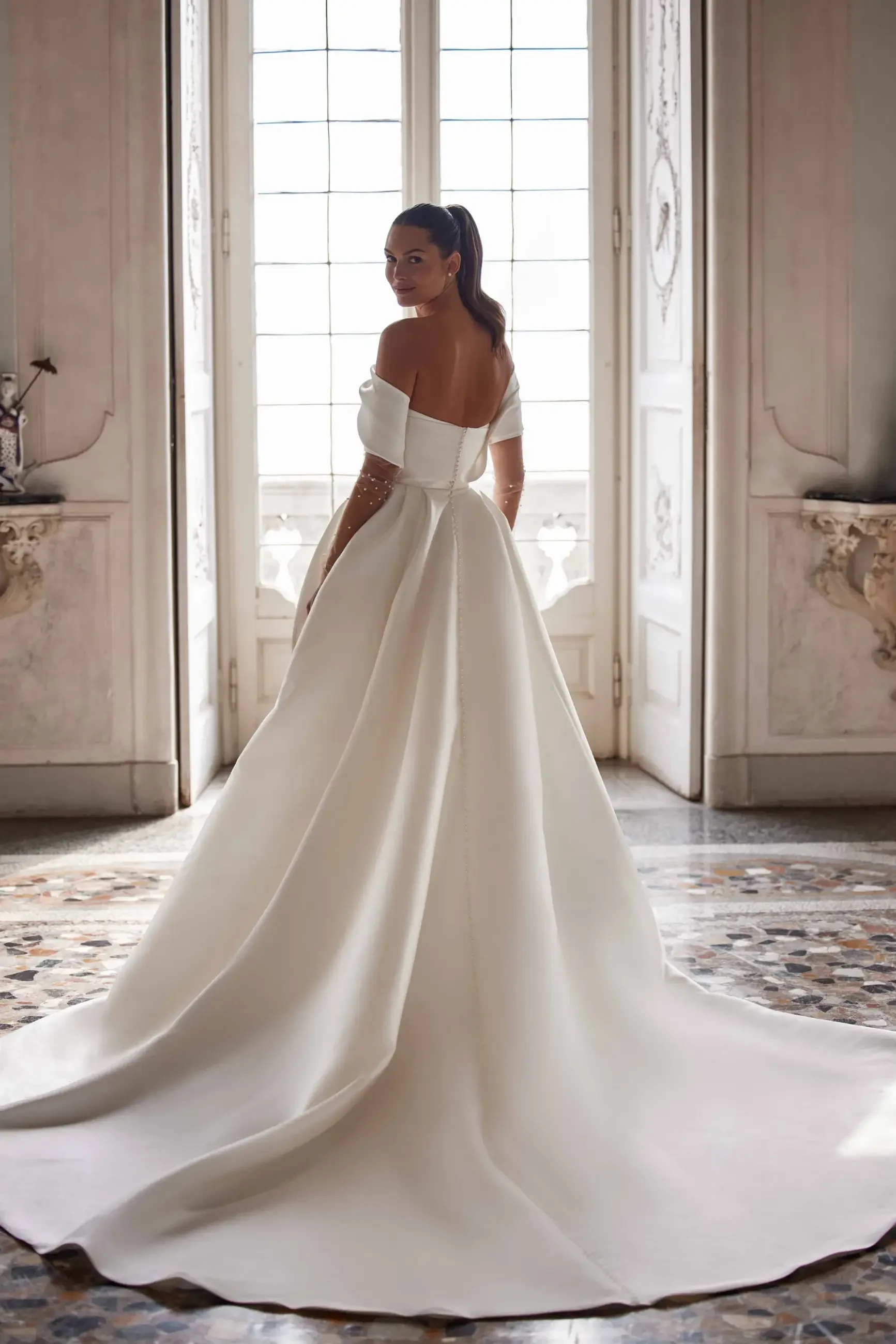 model is wearing a strapless ball gown  with detachable sleeves