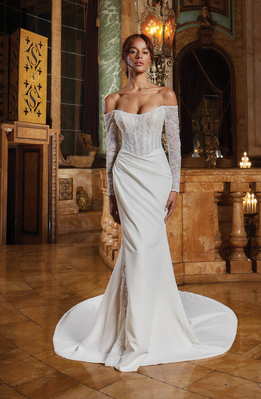 A woman in an elegant off-shoulder white gown with lace details stands in an opulent room with marble and candle-lit ambiance, conveying luxury and grace.