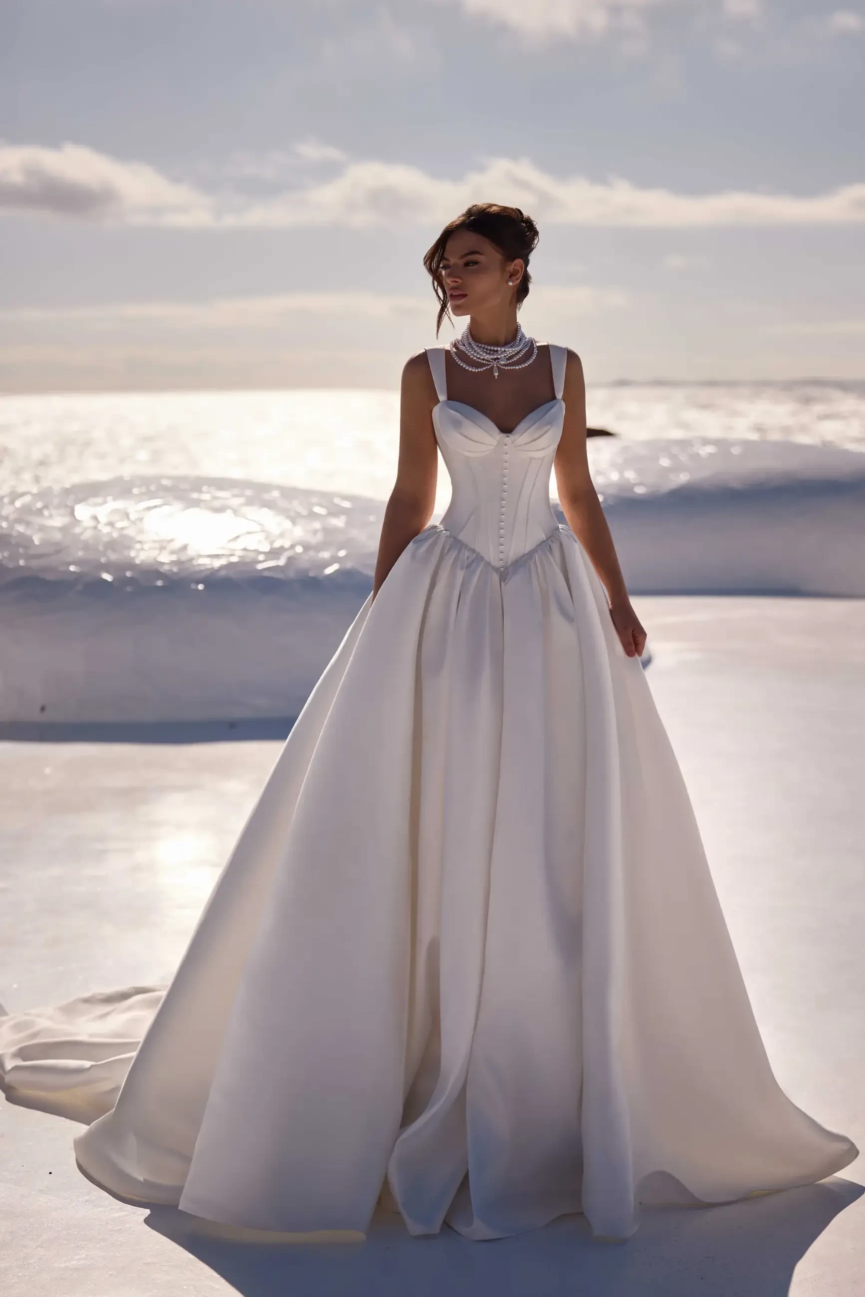 Model is wearing a lustrous mikado ballgown with a heart-shaped neckline, corset bodice with visible boning, and a dramatic full skirt.